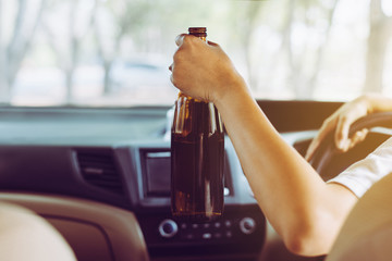 Drunk woman drinking alcohol while driving car on road