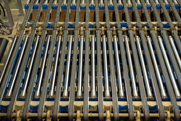 Conveyor belt background: above view of rotating pipes used for transferring materials on production line