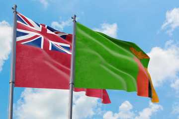 Zambia and Bermuda flags waving in the wind against white cloudy blue sky together. Diplomacy concept, international relations.