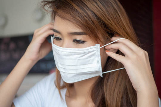 woman wearing face mask from having flu infection; concept of Wuhan virus, corona virus, H5N1, H1N1, bird flu, pig flu, avian influenza, swine influenza, pneumonia, lung inflammation, epidemic fever