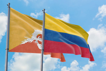 Colombia and Bhutan flags waving in the wind against white cloudy blue sky together. Diplomacy concept, international relations.
