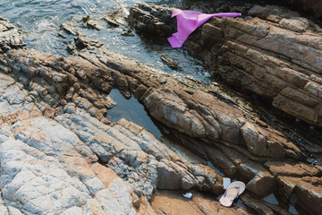 Plastic waste garbage and foam scrap on rock shore and sea beach