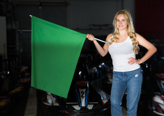 girl holding green flag at kart racing track