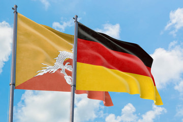 Germany and Bhutan flags waving in the wind against white cloudy blue sky together. Diplomacy concept, international relations.