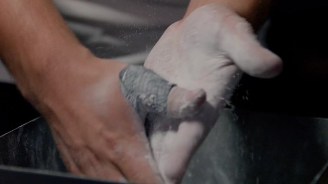 Male Wight Lifter rubbing his Hands with Chalk 