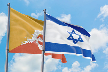 Israel and Bhutan flags waving in the wind against white cloudy blue sky together. Diplomacy concept, international relations.