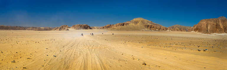 Fototapeta na wymiar Safari tour on quads at the stone desert in Egypt.