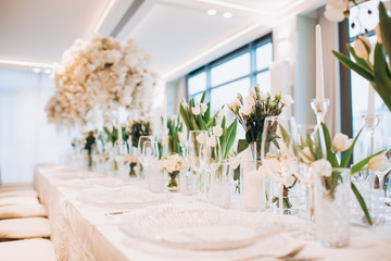 formal luxury elegant wedding decor restaurant tables served white tablecloth, plates, menus,...