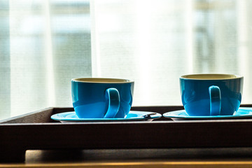 Blurred background view of a mug or coffee cup, a cup of water or a drink on the table, for customer service in a room or restaurant