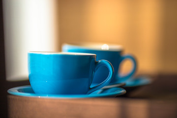 Blurred background view of a mug or coffee cup, a cup of water or a drink on the table, for customer service in a room or restaurant