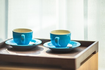 Blurred background view of a mug or coffee cup, a cup of water or a drink on the table, for customer service in a room or restaurant