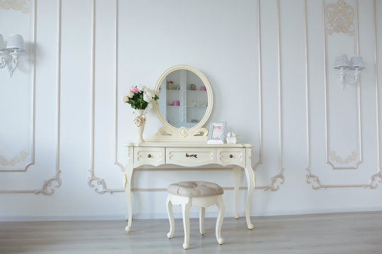 Boudoir table. Details of the interior of the modern classical bedroom for girls and make-up, hairstyles with a mirror
