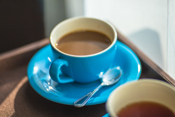 Blurred background view of a mug or coffee cup, a cup of water or a drink on the table, for customer service in a room or restaurant
