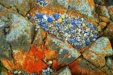 galets colorés entre deux rochers sur une plage