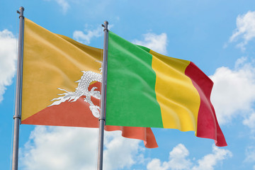 Mali and Bhutan flags waving in the wind against white cloudy blue sky together. Diplomacy concept, international relations.