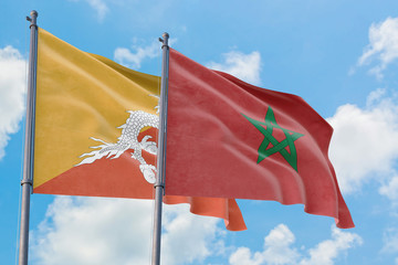 Morocco and Bhutan flags waving in the wind against white cloudy blue sky together. Diplomacy concept, international relations.