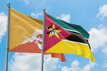 Mozambique and Bhutan flags waving in the wind against white cloudy blue sky together. Diplomacy concept, international relations.