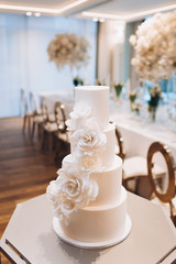 white exquisite luxury three-tier wedding cake with mastic flowers