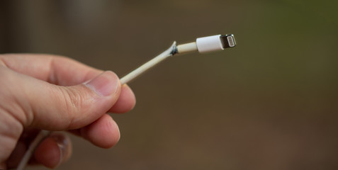 Close-up of broken smartphone's charger cable	