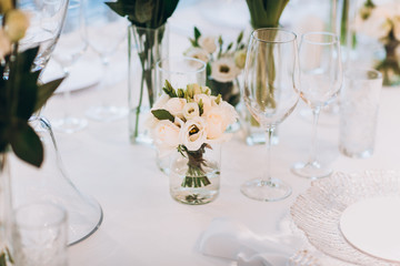 formal luxury elegant wedding decor restaurant tables served white tablecloth, plates, menus, glasses, tulips in vases, orchids, candles silver chairs, blue background