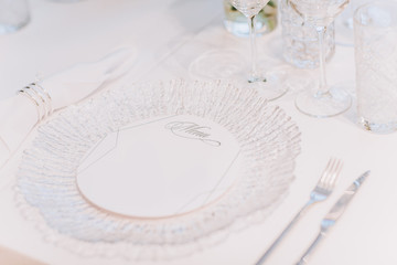 formal luxury elegant wedding decor restaurant tables served white tablecloth, plates, menus, glasses, tulips in vases, orchids, candles silver chairs, blue background