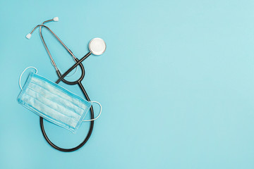 Medical stestoscope and protective mask on a blue background. Concept medicine, nurse, hospital,...