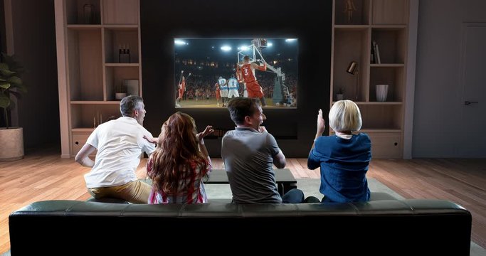 Group of students are watching a basketball moment on the TV and celebrating a goal, sitting on the couch in the living room. The living room is made in 3D.