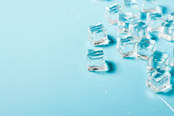 Ice cubes with water on a blue background. Ice concept for drinks. Banner. Flat lay, top view