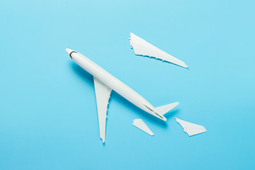 Broken plane on a blue background. The concept of a plane crash, malfunction. Banner. Flat lay, top view