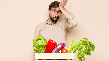 green grocery man raising palm to forehead thinking oops, after making a stupid mistake or...