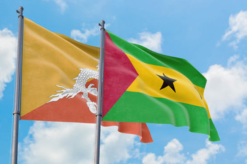 Sao Tome And Principe and Bhutan flags waving in the wind against white cloudy blue sky together. Diplomacy concept, international relations.