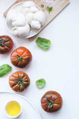 Italian mozzarella cheese in the form of a braid (treccia) with burgundy Pachino tomatoes, olive...