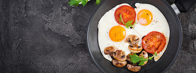 Ketogenic food. Fried egg, mushrooms and sliced tomatoes. Keto, paleo breakfast. Top view, banner