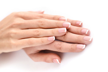 Beautiful woman hands with french manicure on a white background