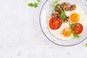 Ketogenic food. Fried egg, mushrooms and sliced tomatoes. Keto, paleo breakfast. Top view, overhead, copy space