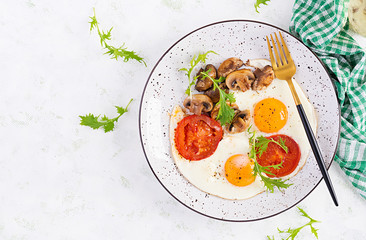 Ketogenic food. Fried egg, mushrooms and sliced tomatoes. Keto, paleo breakfast. Top view, overhead, copy space