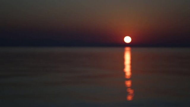 Blurry dramatic dark peaceful sea landscape of sunset or sunrise sky and Aegean sea water. Greece, Chalkidiki beach. Natural abstract video background.