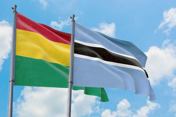 Botswana and Bolivia flags waving in the wind against white cloudy blue sky together. Diplomacy concept, international relations.