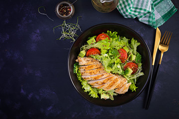 Chicken grilled fillet with salad fresh tomatoes and avocado. Healthy food, ketogenic diet, diet lunch concept. Keto/Paleo diet menu. Top view, flat lay