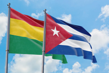 Cuba and Bolivia flags waving in the wind against white cloudy blue sky together. Diplomacy concept, international relations.