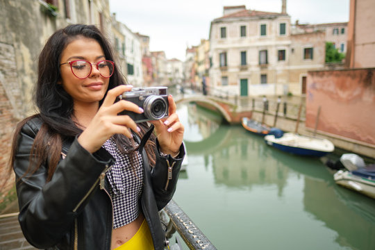 Travel woman photographer in Venice taking picture outside smiling