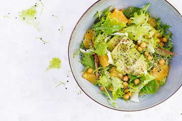 Vegetarian/ vegan salad with boiled chickpeas, greens, avocado, orange and chia seeds. Healthy eating trend, superfood. Top view, flat lay, copy space