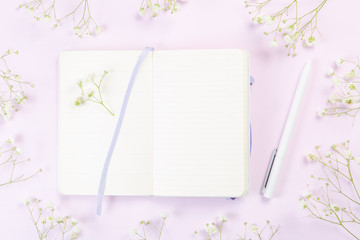 Good morning concept - coffee, flowers, notebook, pink background top view