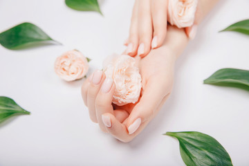 Obraz na płótnie Canvas Concept beauty. Beautiful stylish trendy female pink manicure with flower on background, top view