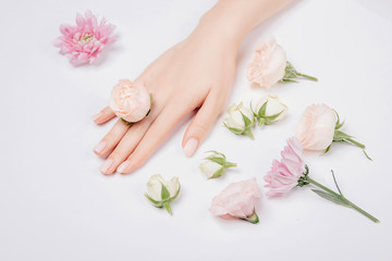 Beautiful stylish trendy female pink manicure with flower on background, top view. Concept beauty