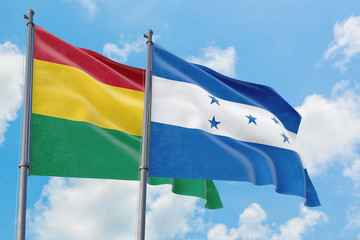 Honduras and Bolivia flags waving in the wind against white cloudy blue sky together. Diplomacy concept, international relations.