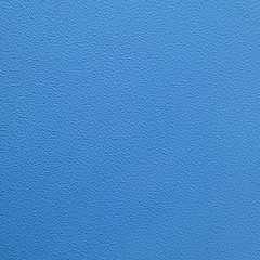Texture of an unevenly painted wall with rough edges, blue background close-up