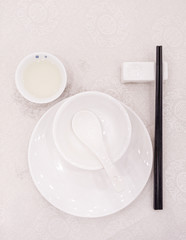 white bowl, spoon, plate, tea cup & rest with black chopsticks