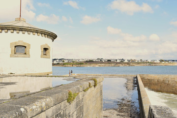 Audierne ville du Finistère en Bretagne sa baie son phare sa jetée le pont et les vagues qui se jettent sur les rochers en projetant de l'écume à marée haute