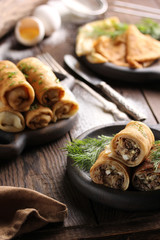 Concept of Russian cuisine. Pancakes with meat on a dark wooden background